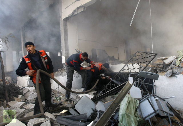 Palestinian firemen extinguish fire from a building following an Israeli air strike in Gaza City on December 29, 2008 (AFP Photo / Mahmud Hams)